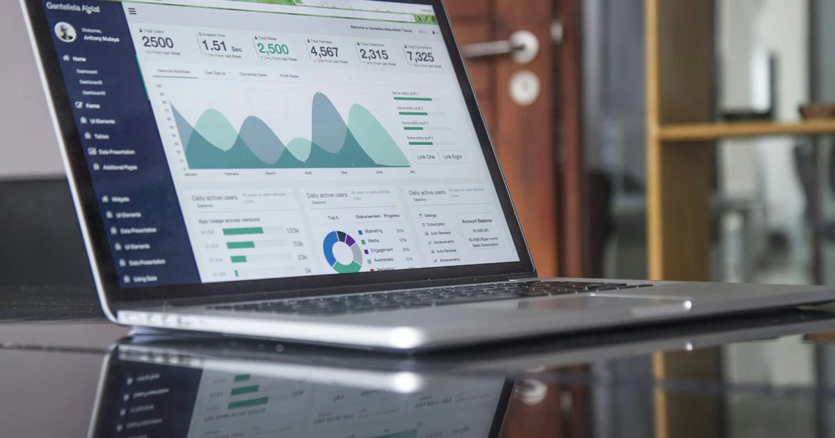 Pessoa analisando gráficos financeiros em um notebook